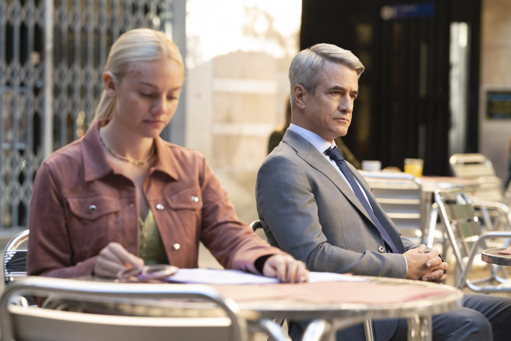 Áine Rose Daly y Dermot Mulroney en una escena de la serie Hanna. Aparecen tomando algo en una terraza en Barcelona. 