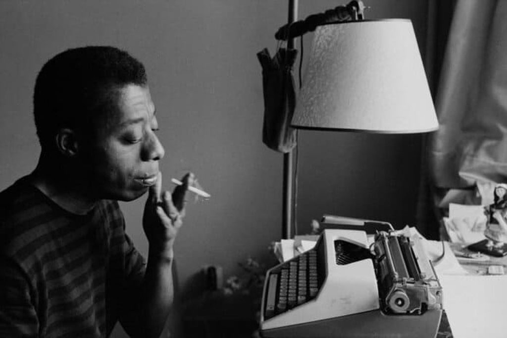 Imagen del escritor James Baldwin escribiendo en su máquina de escribir.